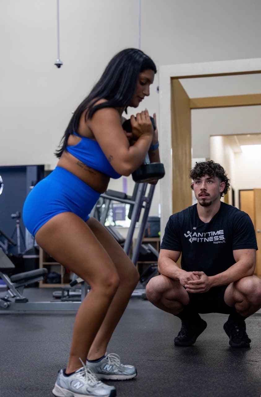 Jeremy watching a client's form during a dumbbell squat